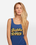Woman wearing a blue tank top with 'Baddie with a Legacy' text on a plain background