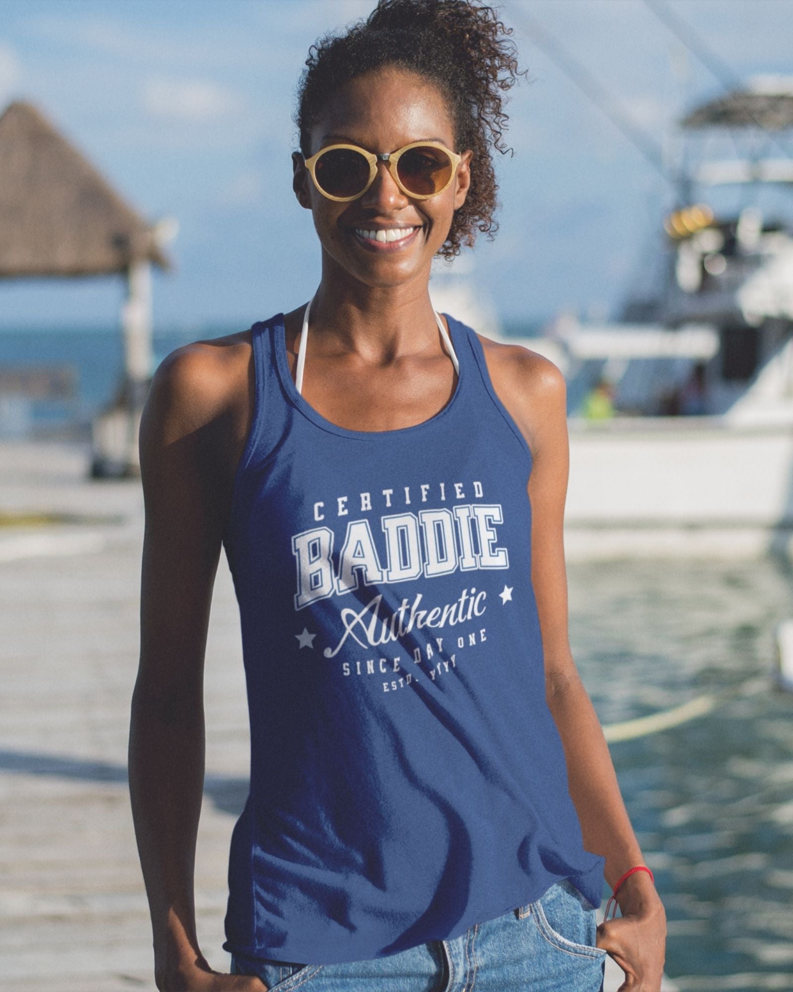 Woman wearing a blue tank top with text by a waterfront