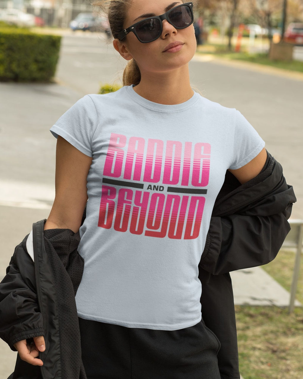 Woman wearing a light blue t-shirt with 'Baddie and Beyond' text in pink and black.