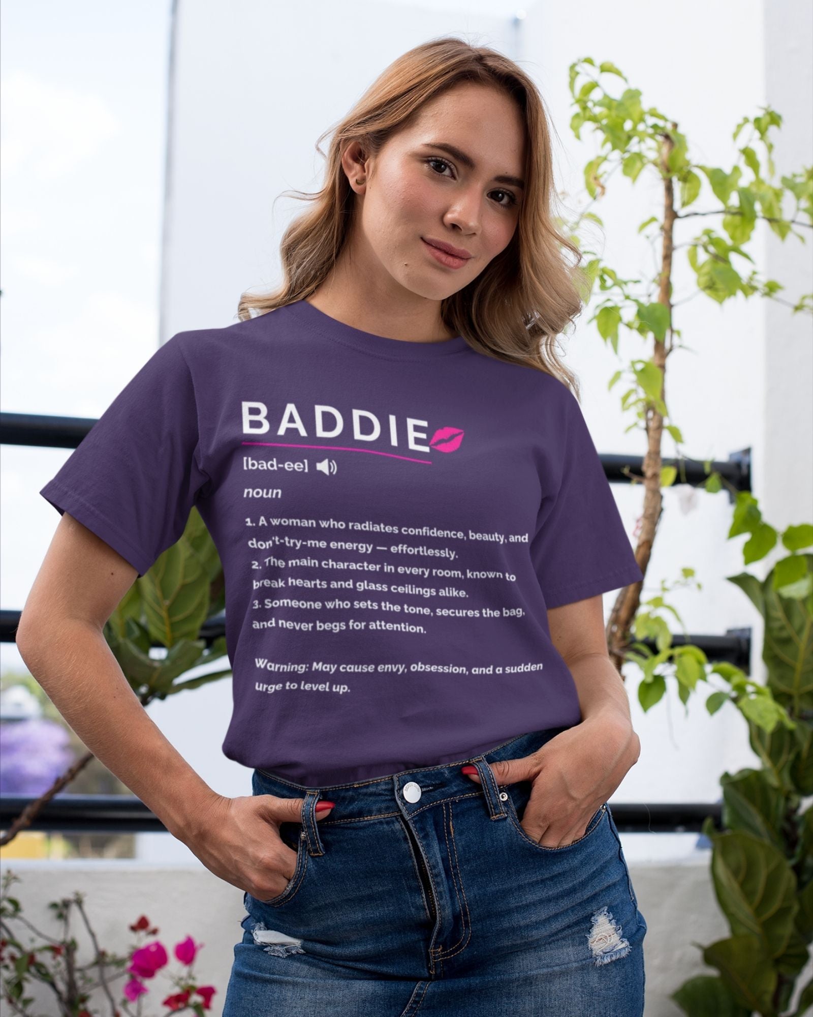Person wearing a purple t-shirt with 'BADDIE' definition text