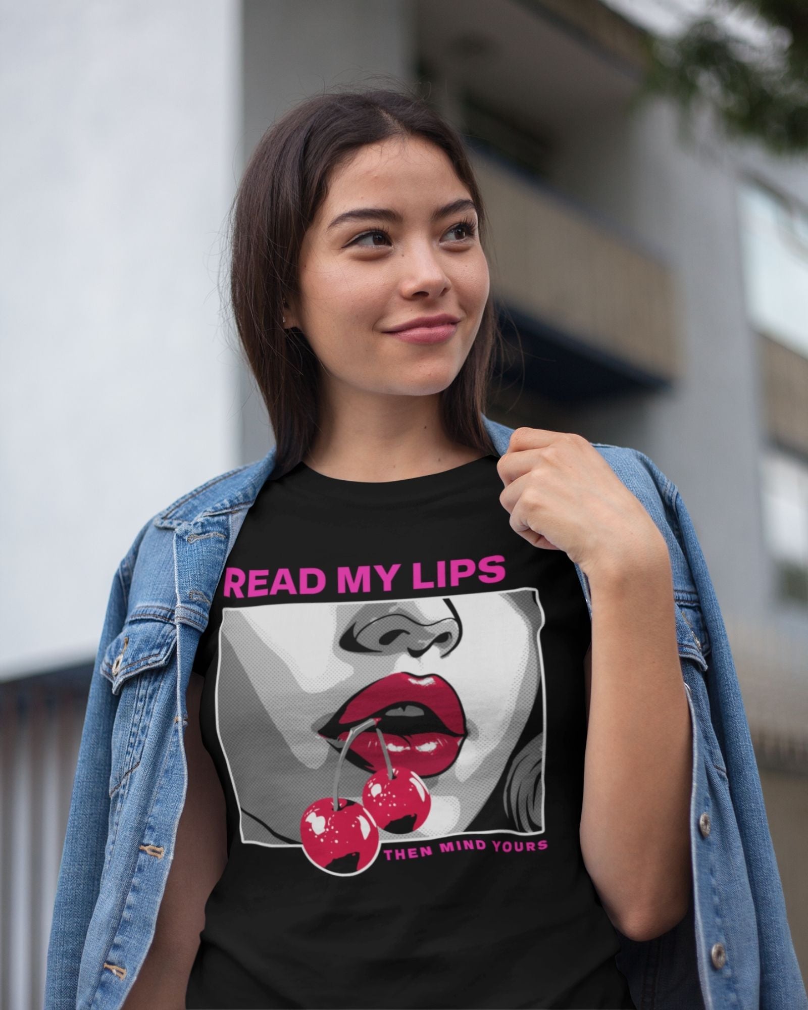 Person wearing a black t-shirt with a graphic design and text, standing outdoors.