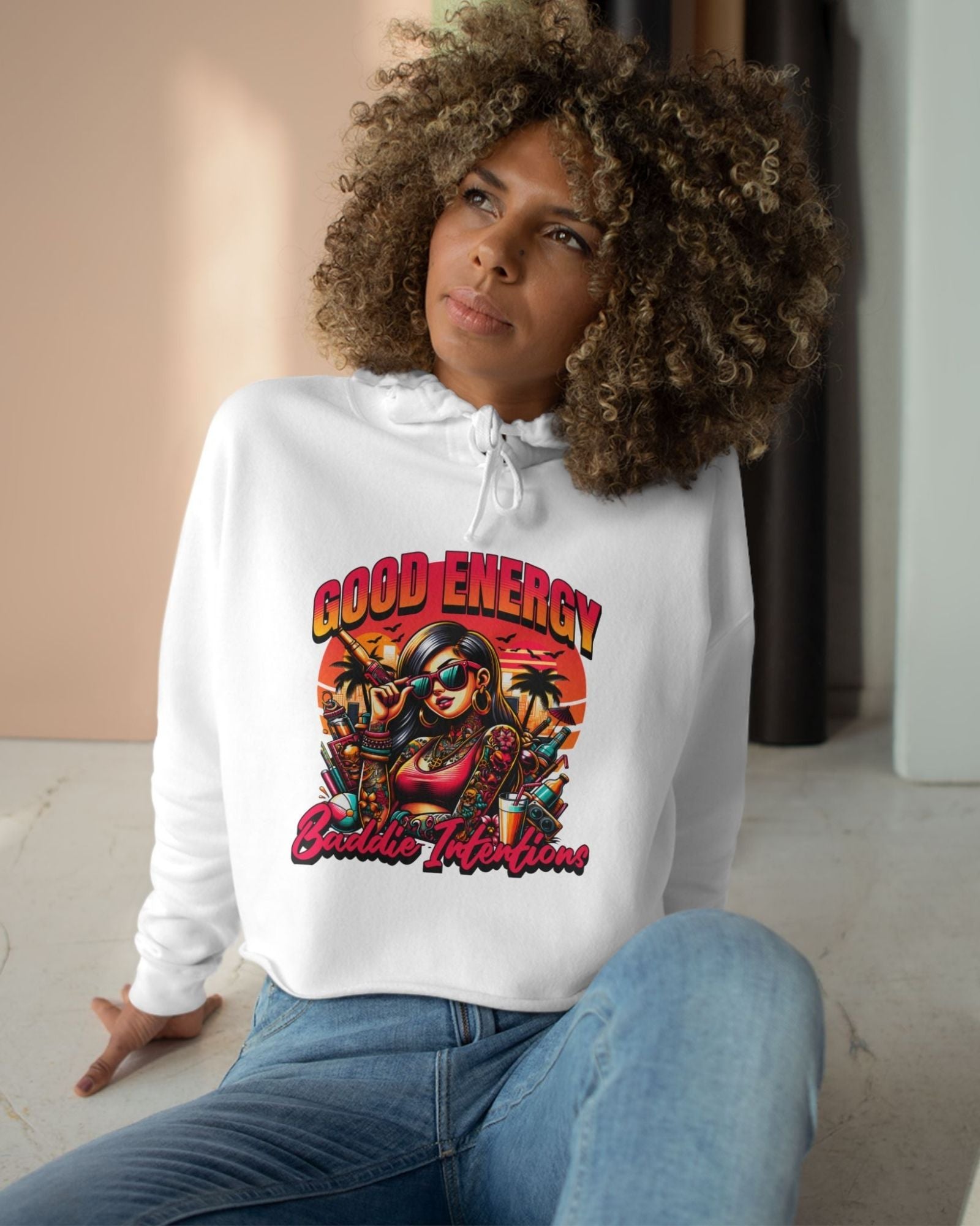 Woman wearing a white hoodie with 'Good Energy Bubble Tea' design sitting on the floor.