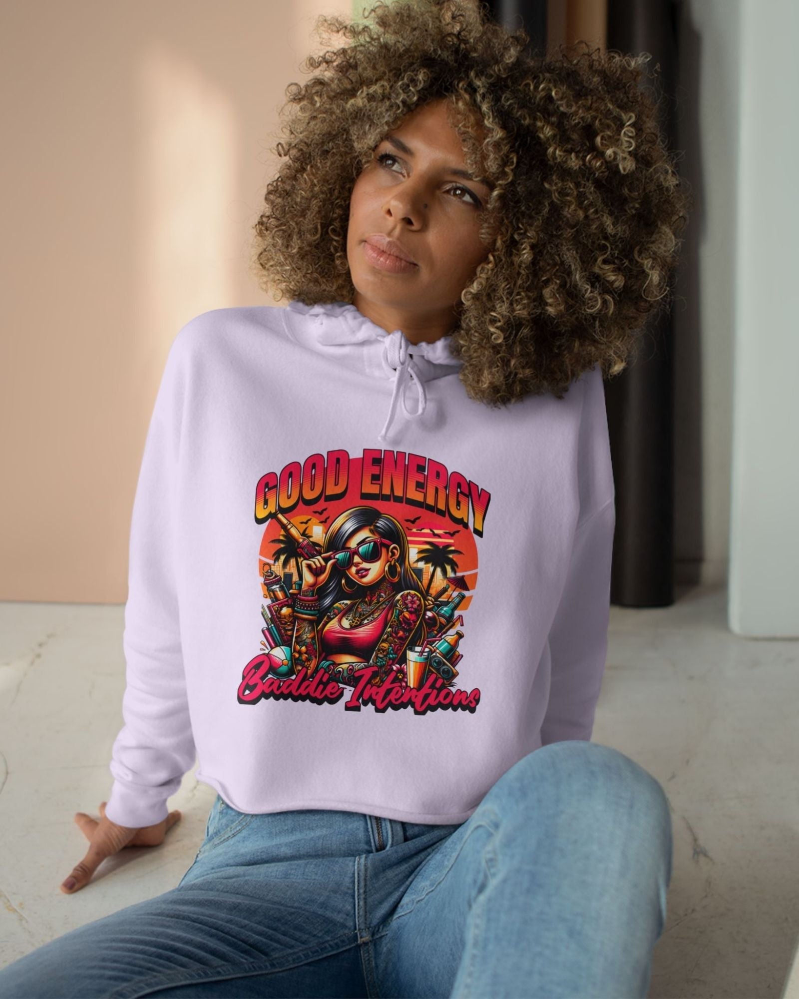 Person wearing a white hoodie with a colorful graphic design sitting on the floor.